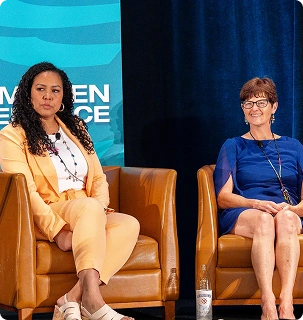 Two women sitting on stage
